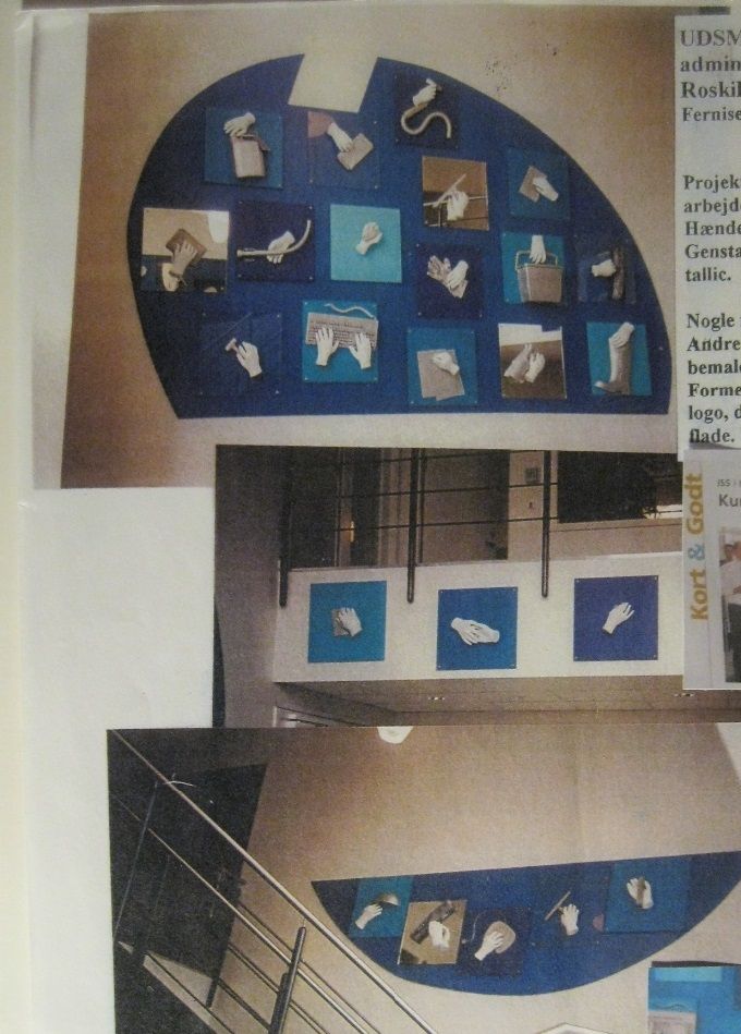Udsmykning i ISS´s tidligere administrationsafdeling i Roskilde, 2002. Hver medarbejder fik sin hånd støbt i gips, og i hånden anbragt det stykke værktøj, som vedkommende beskæftigede sig med.
Alle plader á 50 x 50 cm anbragt på et stort ISS logo.
På modstående væg lidt flere 